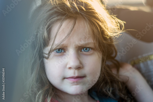 portrait of a cute littele girl with blue eyes looking at camera photo