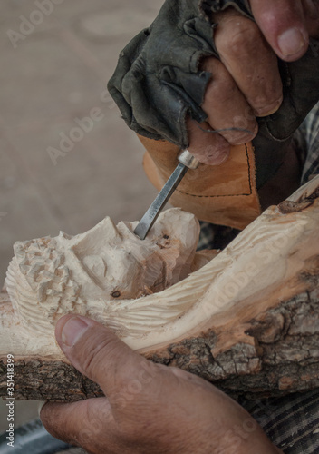 Native Indigenous craftsman working on a Wood carved sculpture of Jesus face Tepatitlan de Morelos, Mexican town photo