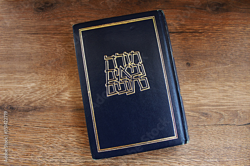 Hebrew Bible book Tanakh (Tanach) on a background of wood (translated from Hebrew on the book Hebrew Bible Tanakh: Torah, Neviim, Ketuvim), Israel photo