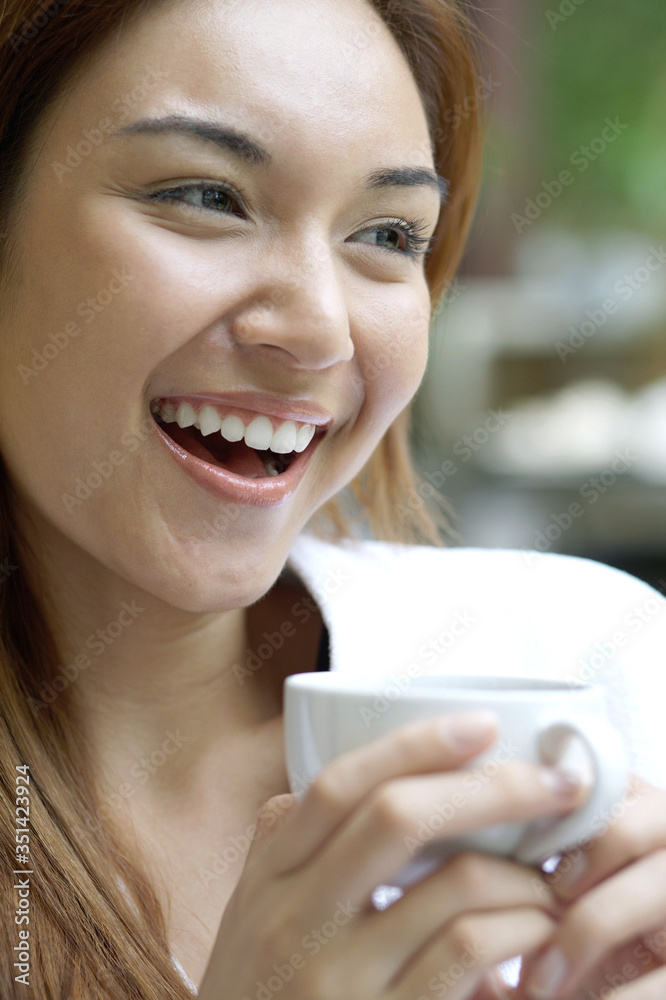 Woman holding a cup while looking away Woman holding a cup while looking away