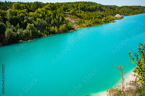 Beautiful landscape - a mountain lake with unusual turquoise water. Stone coast with green trees.