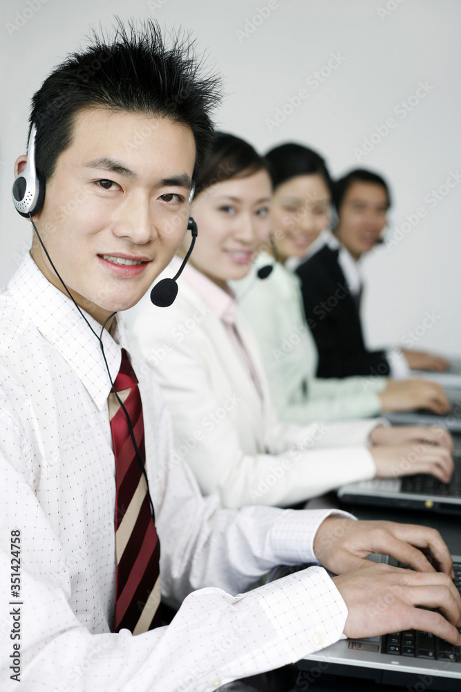 Business people with telephone headset using laptop Business people with telephone headset using laptop
