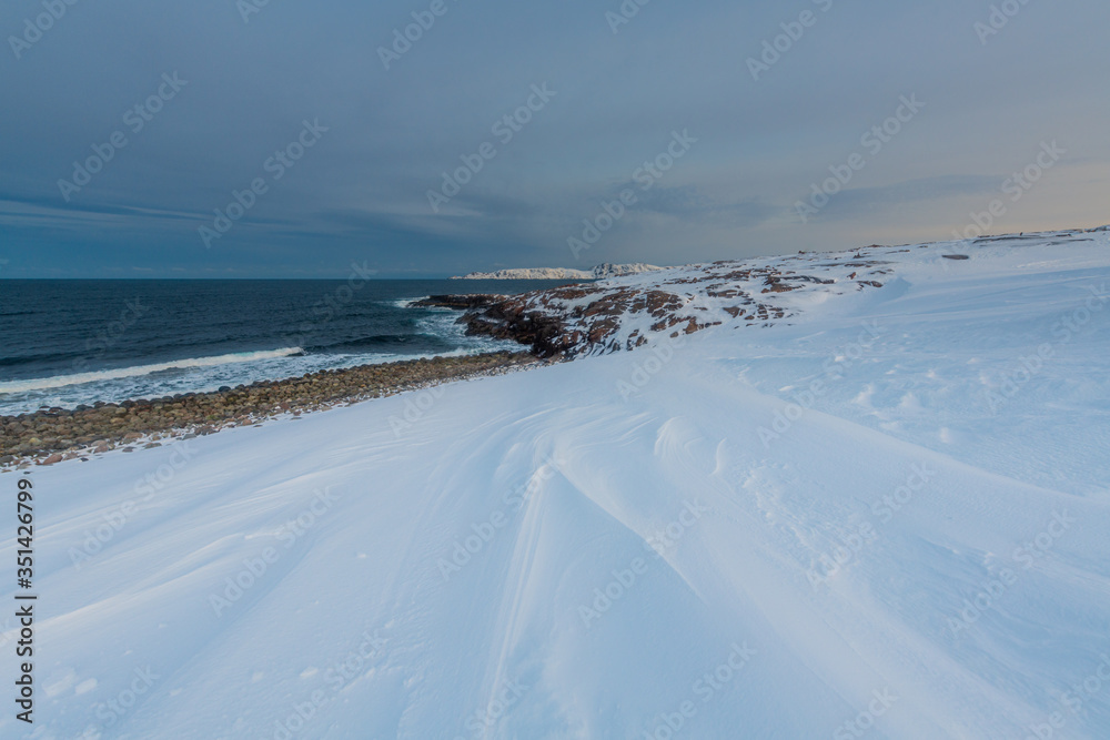 Waves break on the Gulf coast against the backdrop of snow-capped mountains of the Arctic Waves break on the Gulf coast against the backdrop of snow-capped mountains of the Arctic