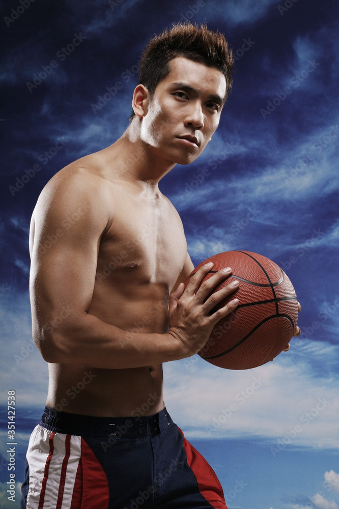 Man holding basketball while looking at camera