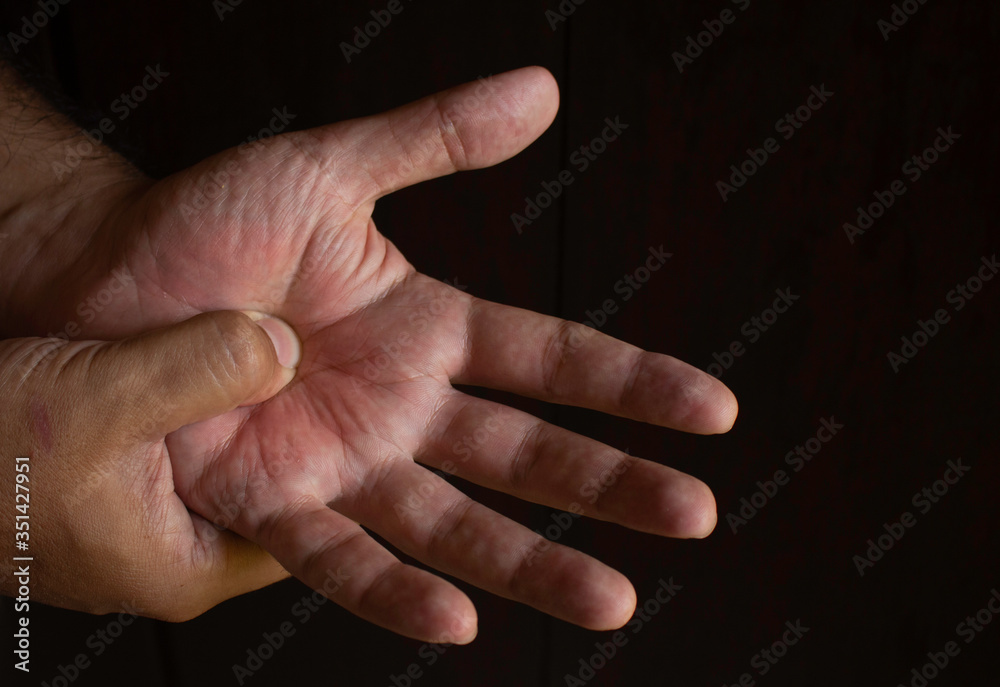 Adult man with pain in his hands. Automassage of hands to relieve pain. Adult man with pain in his hands. Automassage of hands to relieve pain.