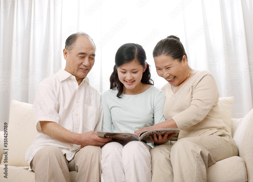 Woman reading magazine with senior man and woman