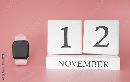 Modern Watch with cube calendar and date 12 november on pink background. Concept autumn time vacation.