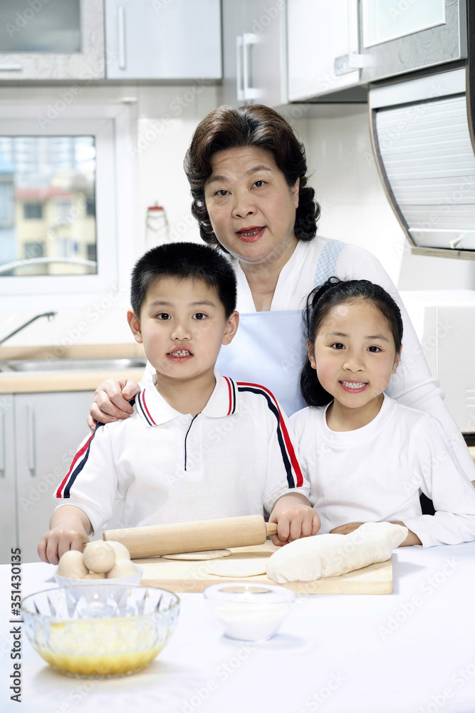 Senior woman, boy and girl baking in the kitchen