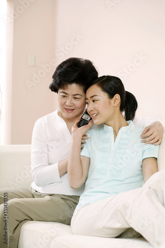 Two women listening to mobile phone