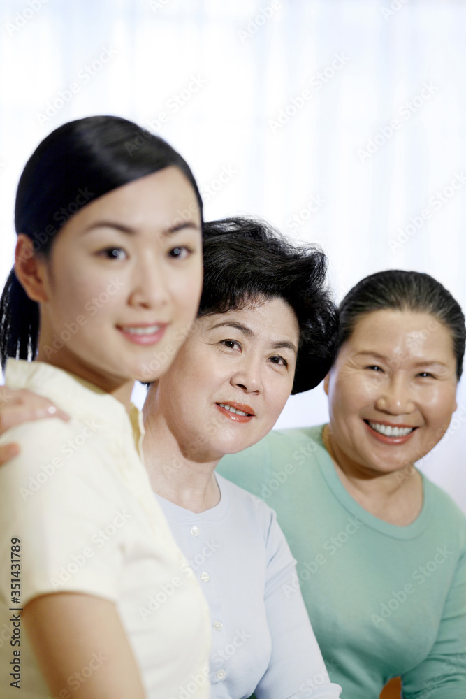 Female generations of a family smiling at the camera Female generations of a family smiling at the camera