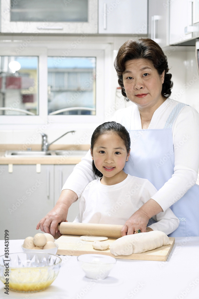 Senior woman and girl baking in the kitchen Senior woman and girl baking in the kitchen