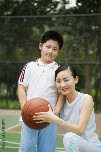 Woman and boy posing with basketball