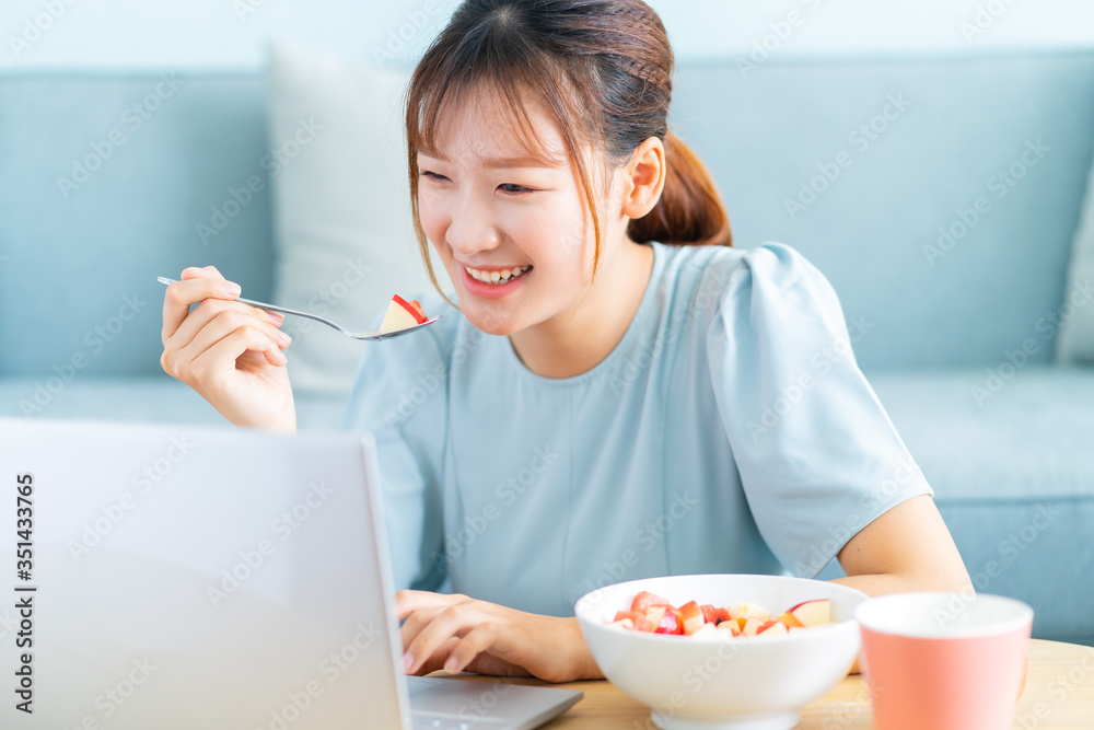 Young Asian woman eating breakfast and selfie in her living room Young Asian woman eating breakfast and selfie in her living room