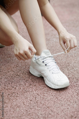 Woman tying up her shoe lace