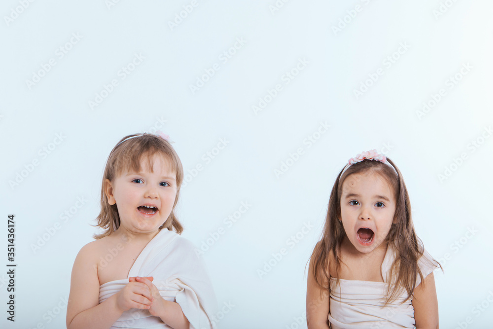 two little girls with their mouths wide open on a white background. The children are playing. the concept of education , childhood, emotions, dentistry, surprise, friendship. Copy space two little girls with their mouths wide open on a white background. The children are playing. the concept of education , childhood, emotions, dentistry, surprise, friendship. Copy space