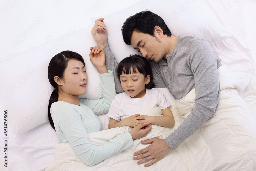Man and woman sleeping with girl in between them Man and woman sleeping with girl in between them