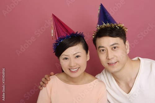 Man and woman wearing party hats