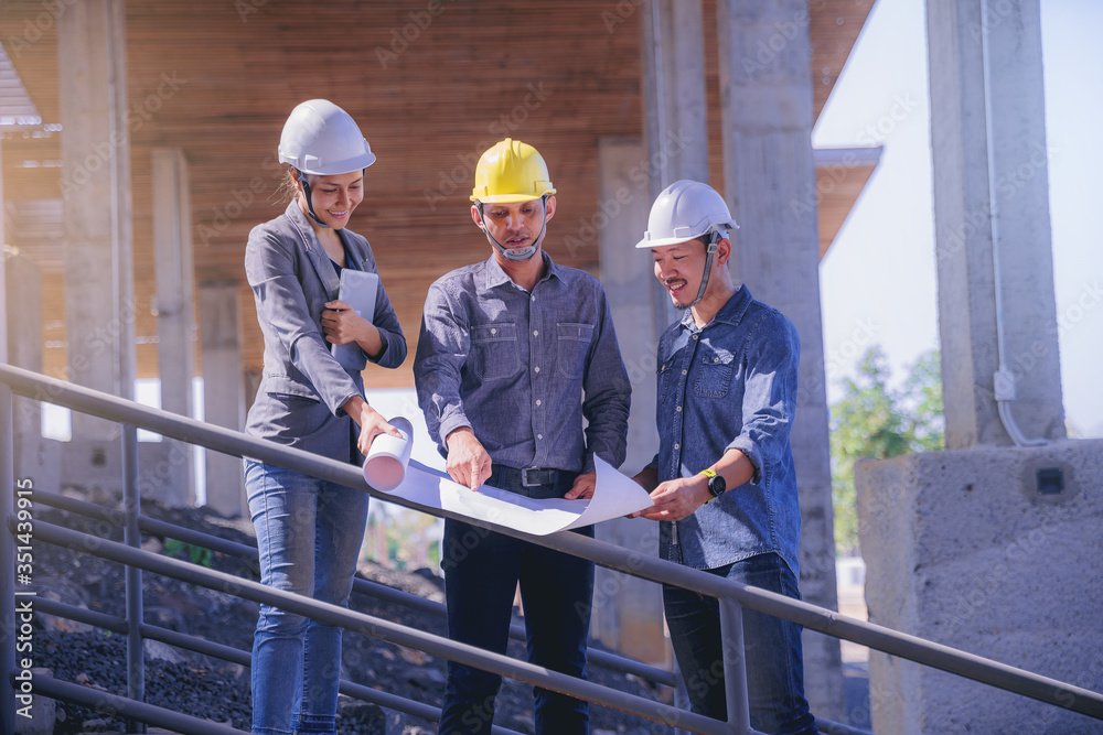 Structural engineer and architect working with blueprints discuss at the building structure, outdoor construction site Structural engineer and architect working with blueprints discuss at the building structure, outdoor construction site