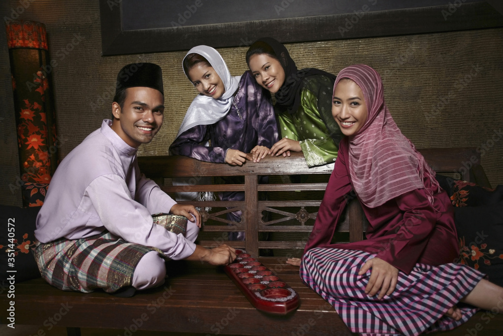 Man and women having fun playing congkak Man and women having fun playing congkak