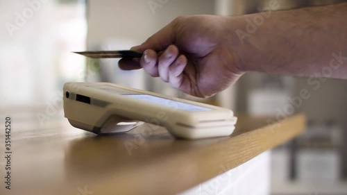 Small business tap payment with card. Point of sale system in small business. Paying with a card. Business is opening up and again. Shot in 4k.