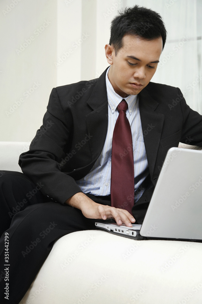 Businessman sitting on the couch using laptop Businessman sitting on the couch using laptop