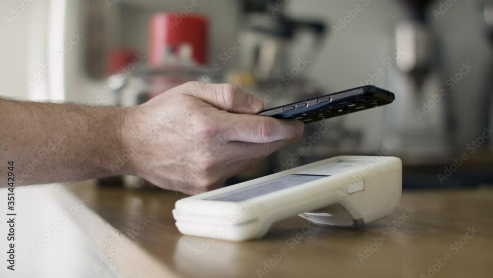Smartphone payment with tap wireless system in a small shop. POS system in small business. Payment with smartphone tap option. Shot in 4k.