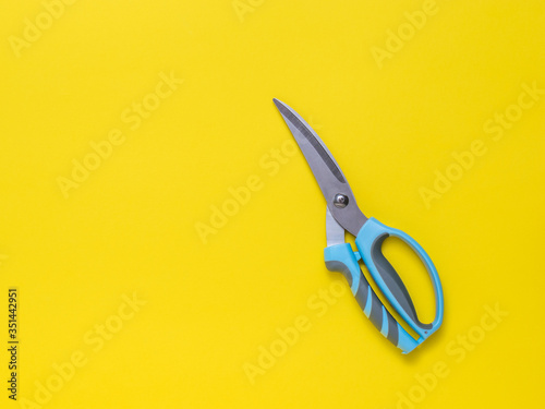 Kitchen scissors on a yellow background. Flat lay.