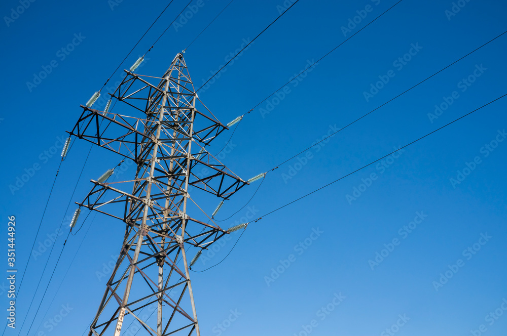 Pylon of an overhead power line (transmission pylon) against a blue sky Pylon of an overhead power line (transmission pylon) against a blue sky