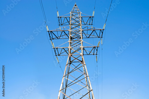 Pylon of an overhead power line (transmission pylon) against a blue sky