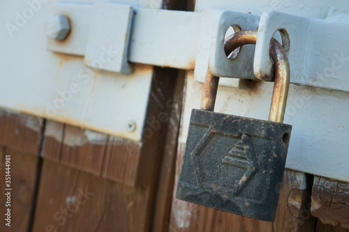 old padlock hanging on an old fence closeup