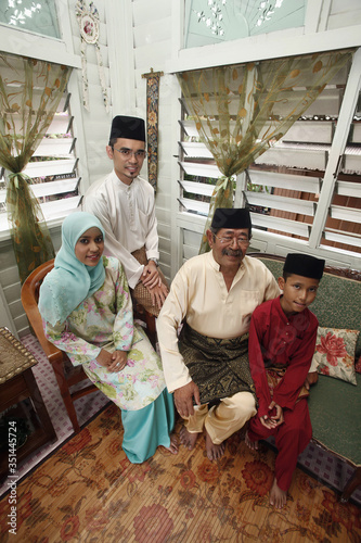 Couple sitting in the living room with senior man and boy