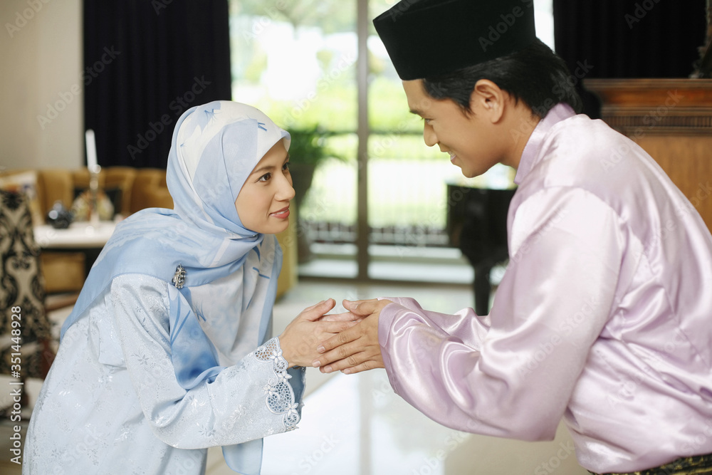Man and woman greeting during Hari Raya Man and woman greeting during Hari Raya