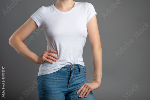 Girl in a white T-shirt with space for logos, advertising, notes. On a gray background for design and replacement background, isolate
