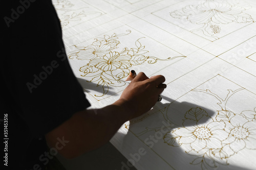 Canvas Print Man drawing batik patterns on fabric