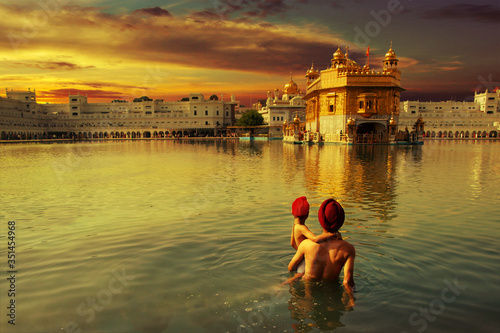 pilgrim at the golden temple in the city of Amritsar-India,main temple of sikh people during sunset time	
 photo