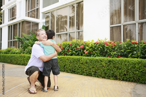 Man hugging boy