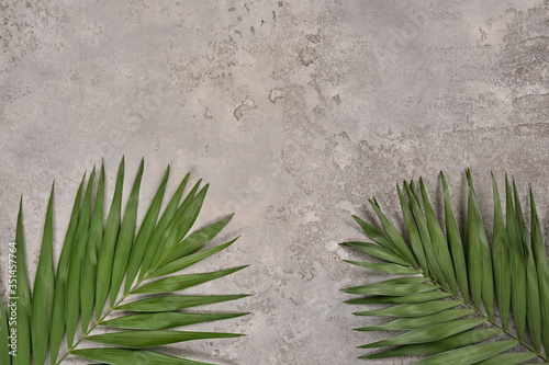 Tablou pe pânză Tropical palm leaves on light gray textured background