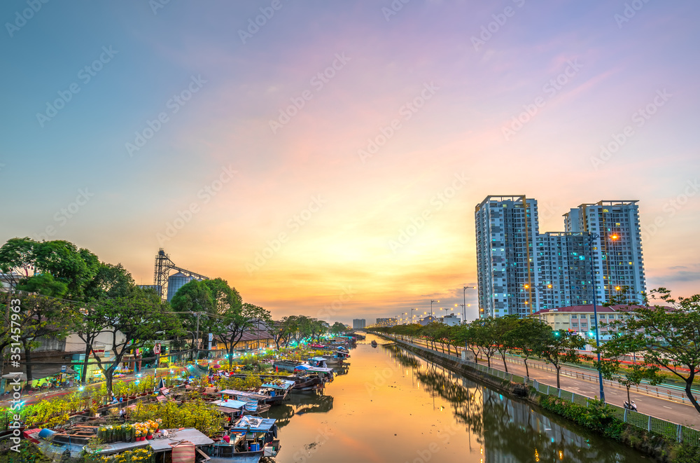 Flower boats full of flowers parked along canal wharf in sunset, a place for bustling flower market trade lunar new year in Ho Chi Minh City, Vietnam