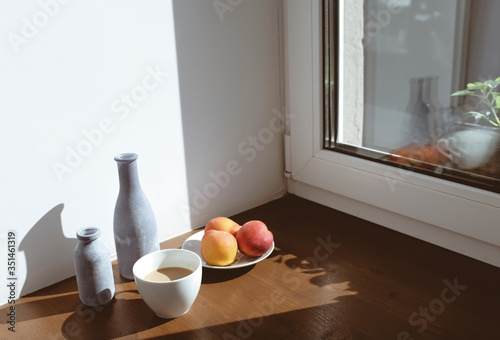 High Angle View Of Fruits With Drink On Wooden Table By Window