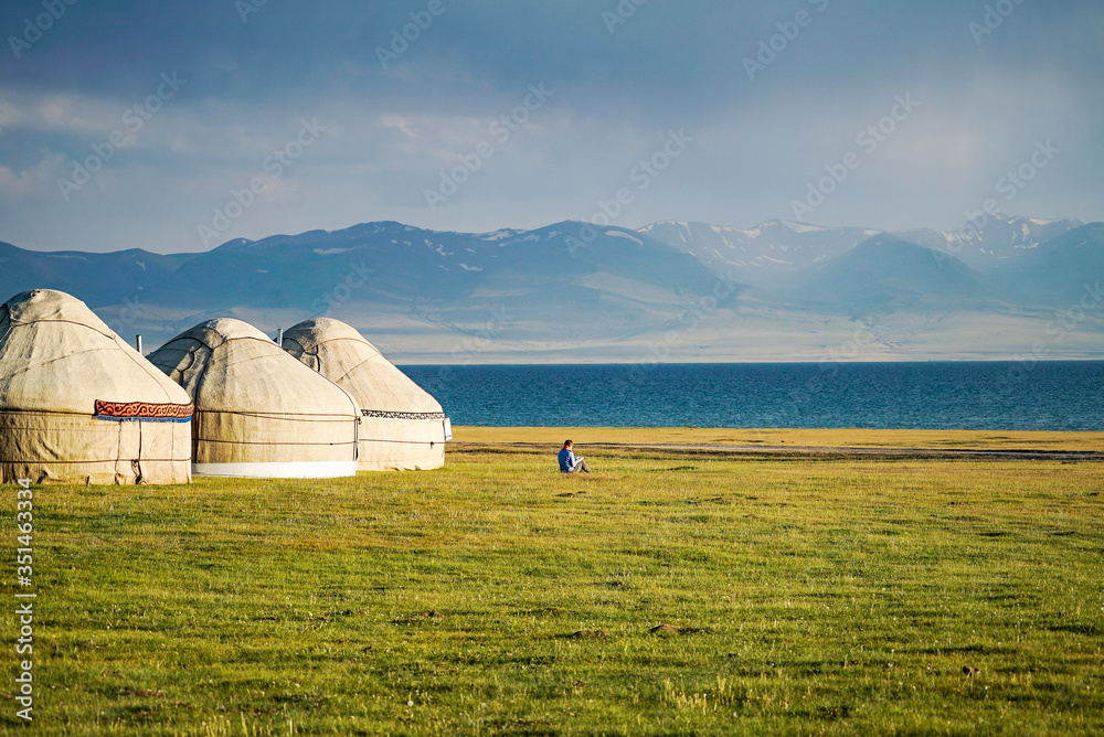 Reading a book at the side of Yurts at Song Kul Lake during sunset, Kyrgyzstan