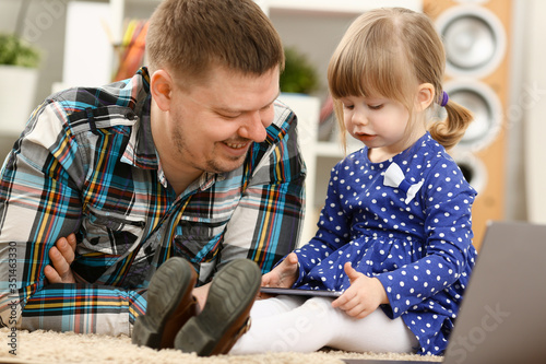 Cute little girl on floor carpet with dad