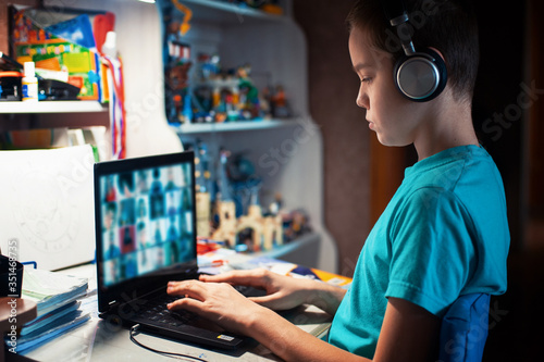 Distance learning or online education conference concept. Schoolboy studies at home and does school homework by laptop