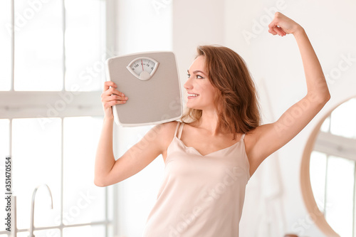 Young woman with weight sca...