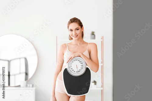 Young woman with weight sca...