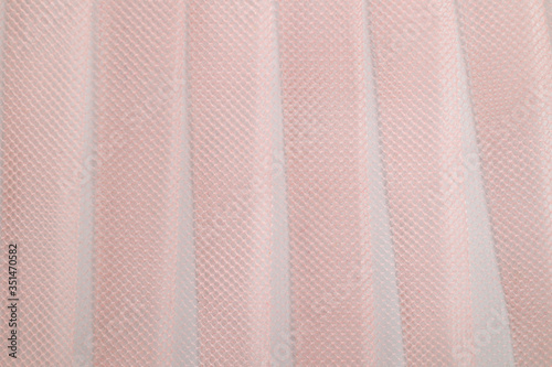 Pleased pink tulle, photographed close-up. Background for the texture of outerwear and fashion.