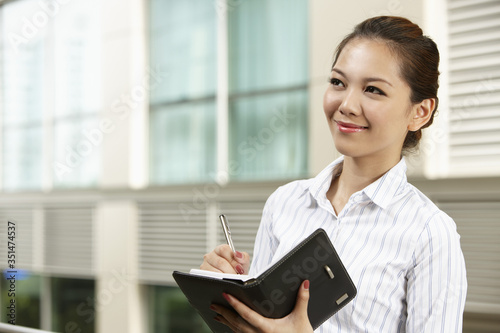 Businesswoman with organizer and pen, smiling