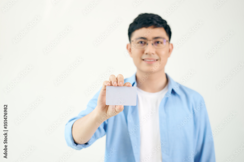 Portrait of smiling Asian man holding white blank business card on white background Portrait of smiling Asian man holding white blank business card on white background