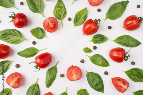 Top above overhead view photo of basil leaves cherry tomatoes and peppercorns isolated on white background