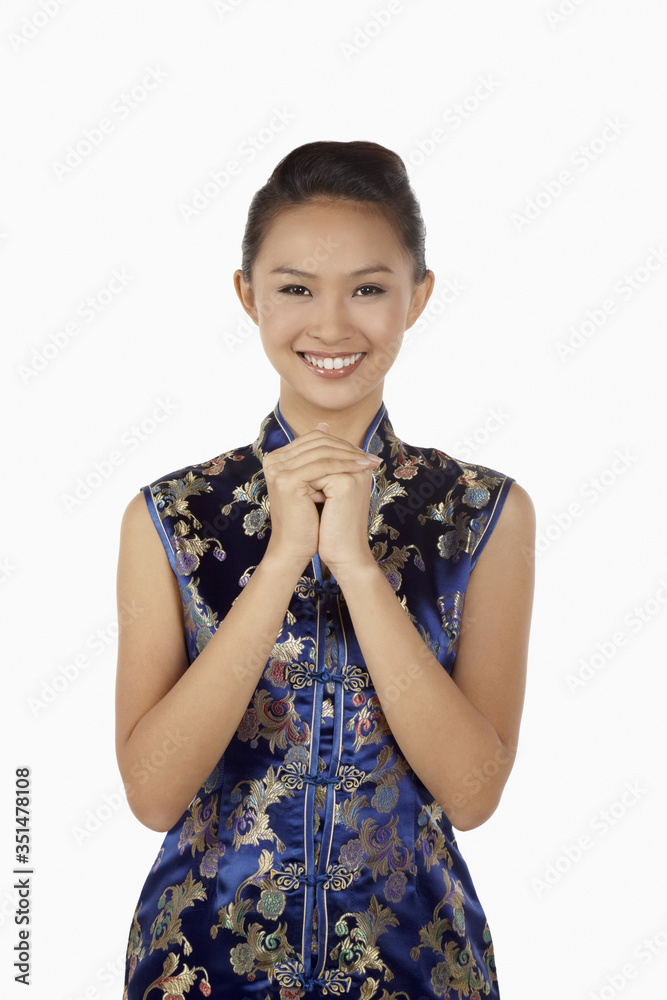 Woman in cheongsam with hands clasped wishing Happy Chinese New Year Woman in cheongsam with hands clasped wishing Happy Chinese New Year