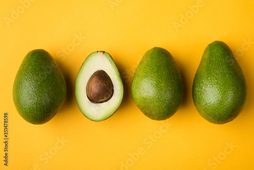 Healthy eating concept. Top above overhead close-up view photo of cut avocado isolated on yellow background